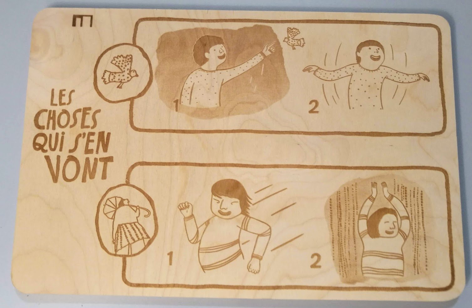 The laser engraved wooden panel, propped on the floor in front of the projection