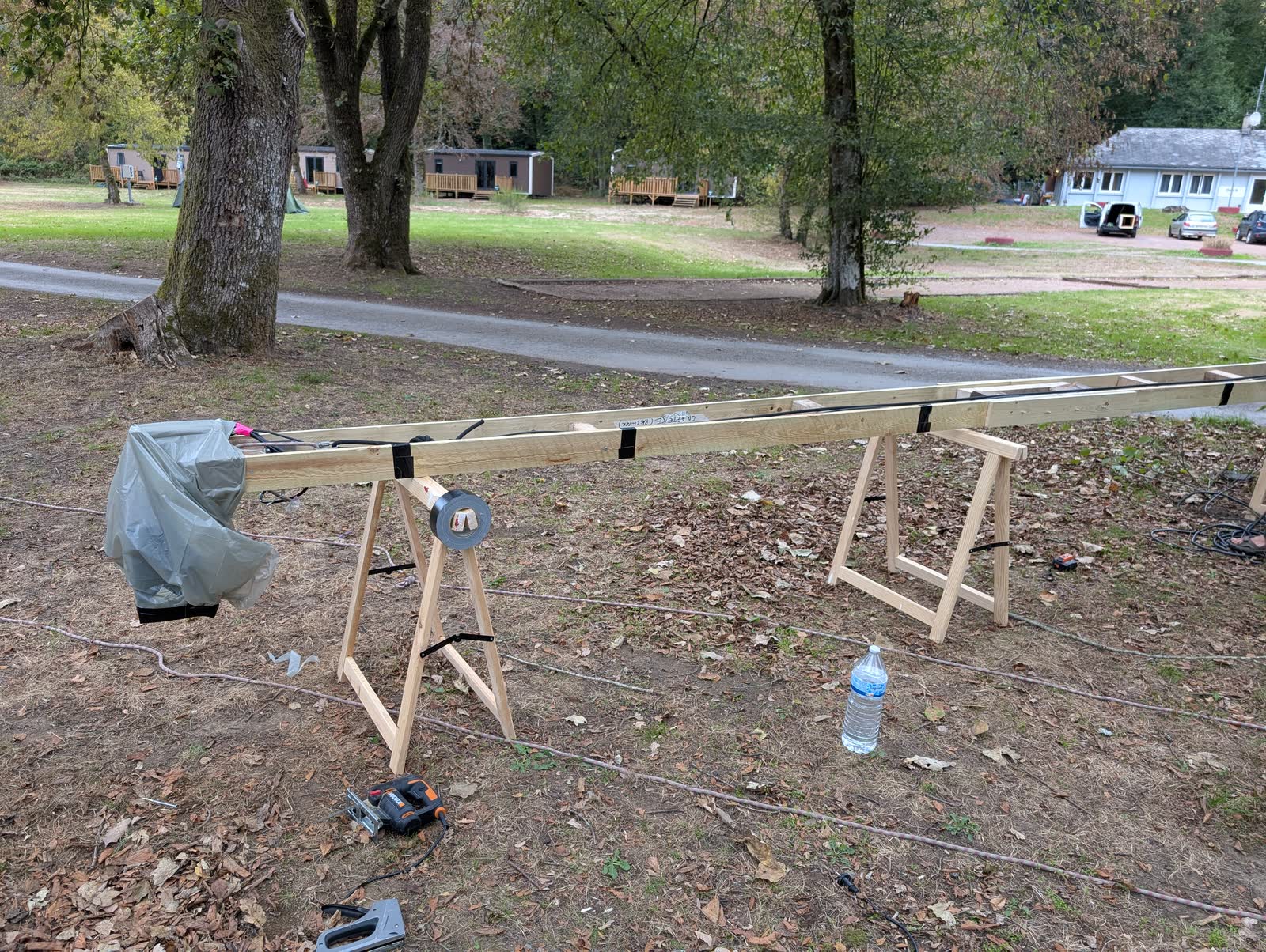 The wooden mast assembled on trestles, laser head wrapped, before the lift