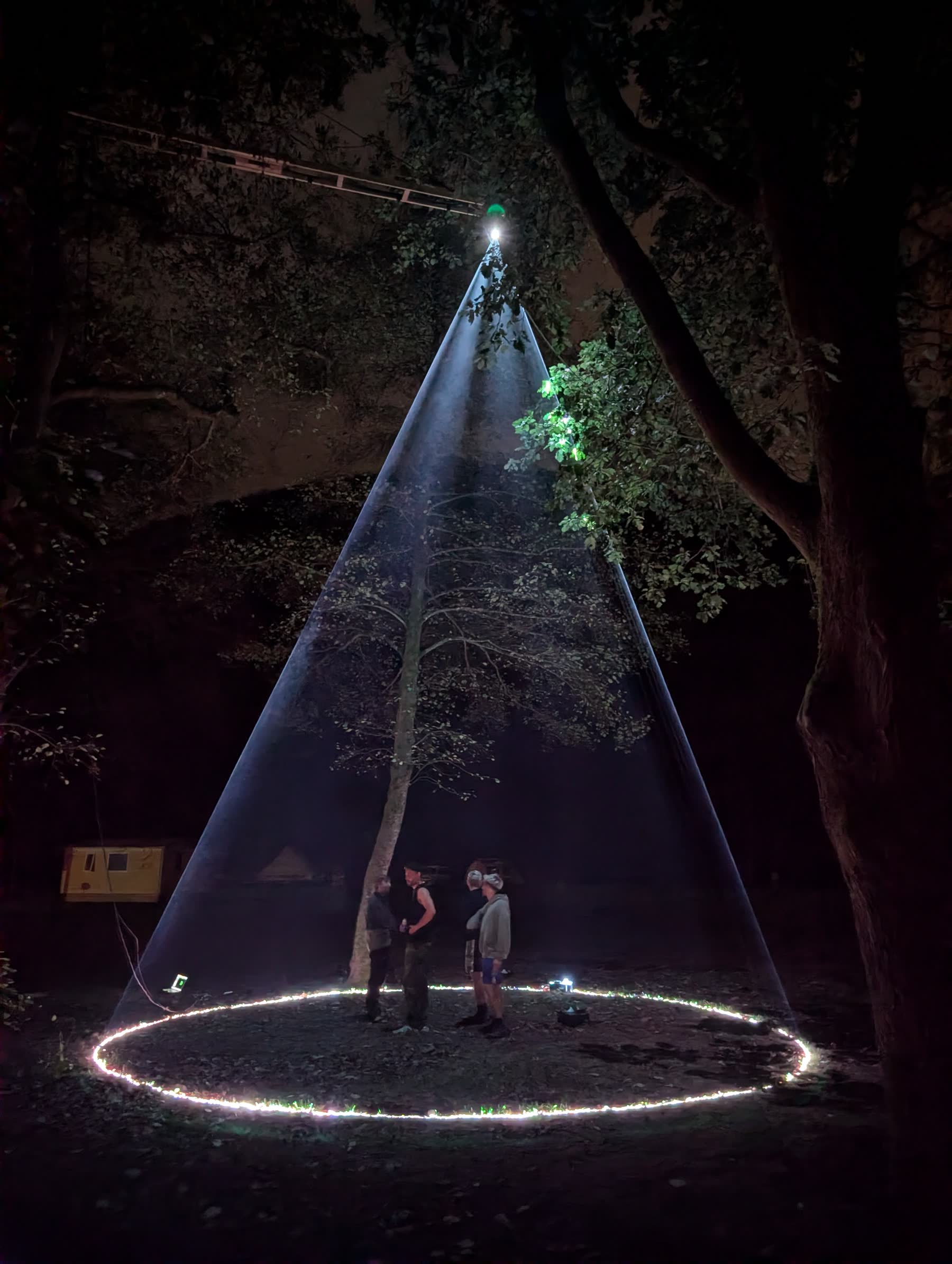 The laser tipi seen from outside, three people standing inside